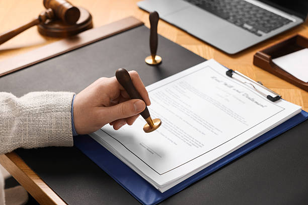 Notary stamping document at table, closeup view